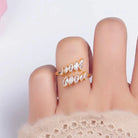 Hand wearing a gold ring with diamonds on background