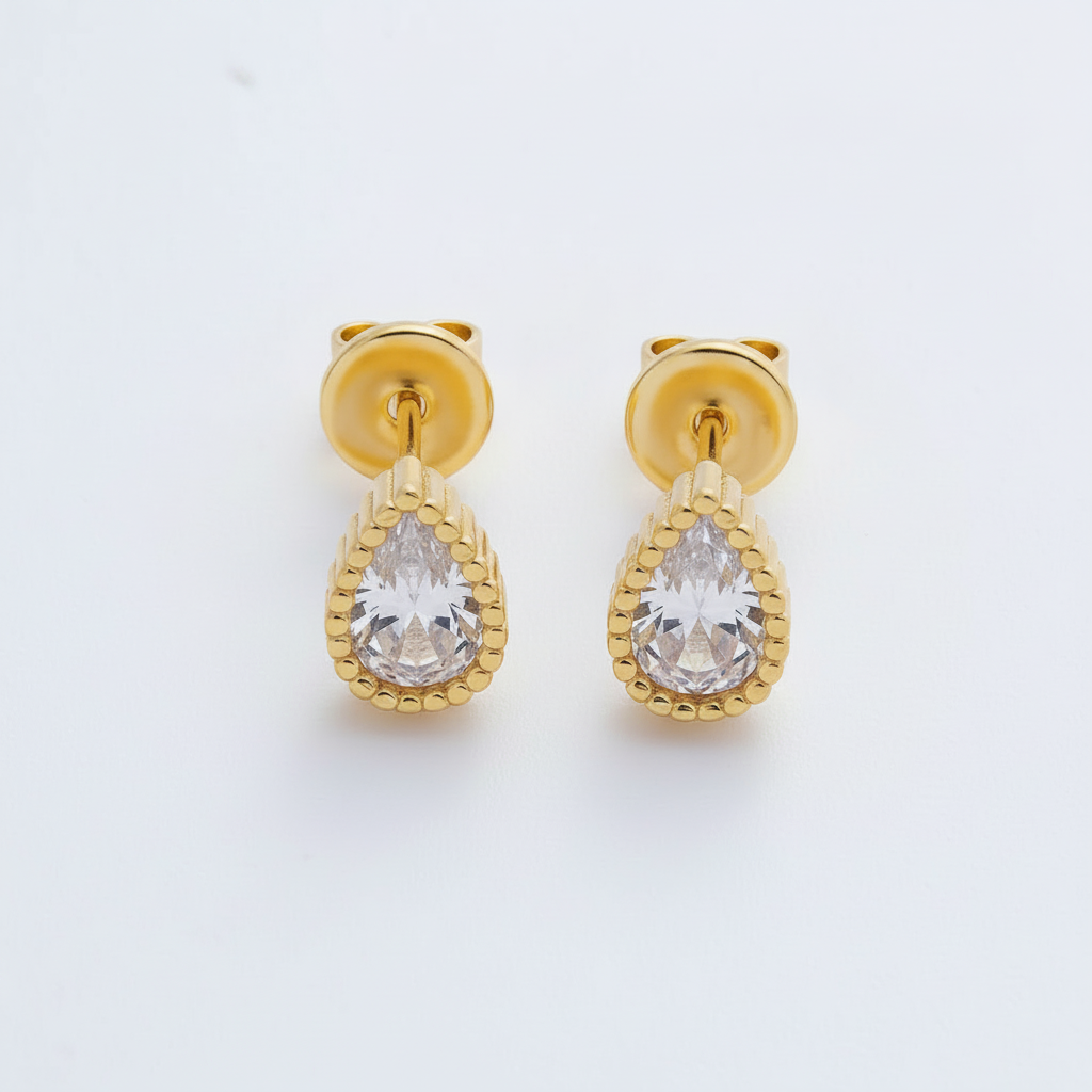 Gold teardrop earrings with clear gemstones on a white background
