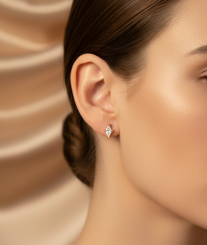 Close-up of a woman wearing diamond earrings against a beige fabric background