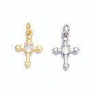 Gold and silver cross-shaped pendants with heart details on a light gray background