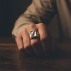 Hand wearing a ring with a dark background
