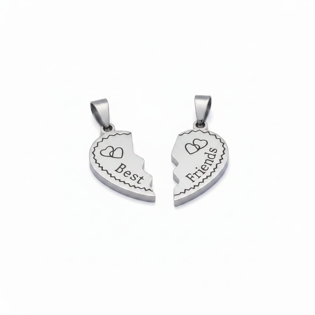 A pair of silver-toned half-heart pendant charms that fit together, engraved with the words 'Best Friends' and small heart motifs, shown on a light lavender background.