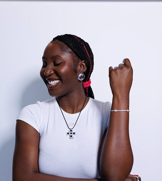 Woman wearing a white shirt with jewelry on a light gray background
