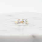 Gold earrings with clear gemstones on a light gray background