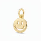 A polished gold smiley face charm pendant with a hanging loop, shown on a clean light gray background.