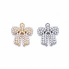 Two pearl bow charms on a light lavender background, one with gold-tone metal and one with silver-tone metal.