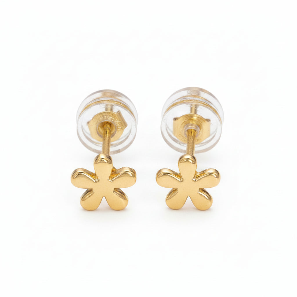 Gold flower-shaped earrings on a light purple background