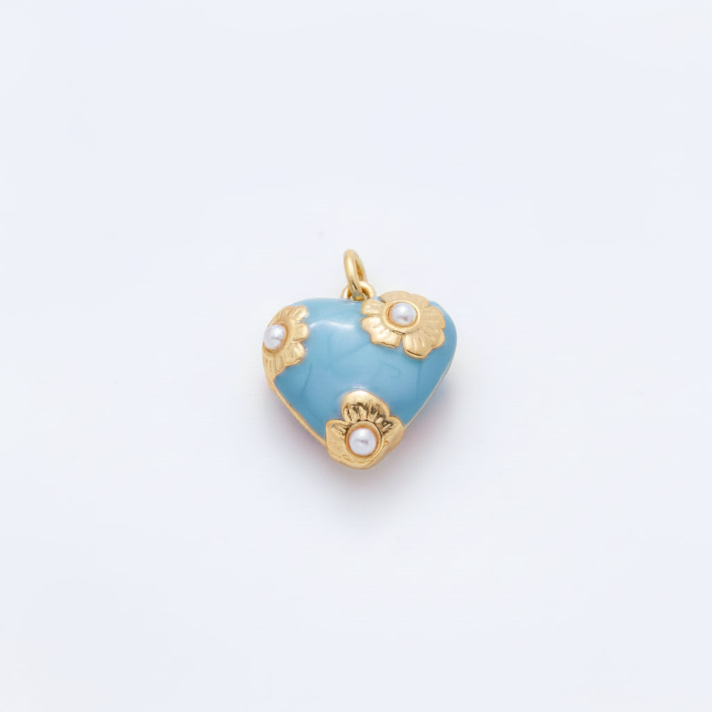 A pair of heart-shaped gold and light blue enamel earrings with pearl-like floral accents, displayed on a clean white background.