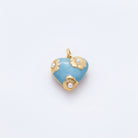 A pair of heart-shaped gold and light blue enamel earrings with pearl-like floral accents, displayed on a clean white background.