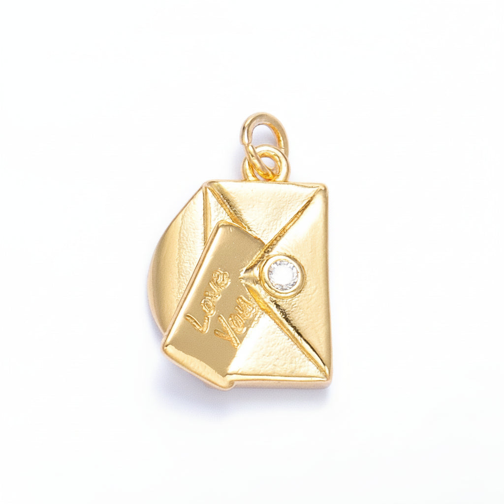 A gold-colored charm shaped like a folded envelope with the words 'Love You' engraved on the front flap and a small clear rhinestone accent, shown on a light blue background.