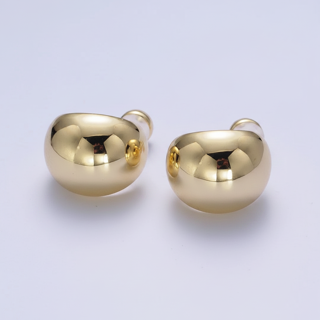 Pair of gold earrings on a light gray background