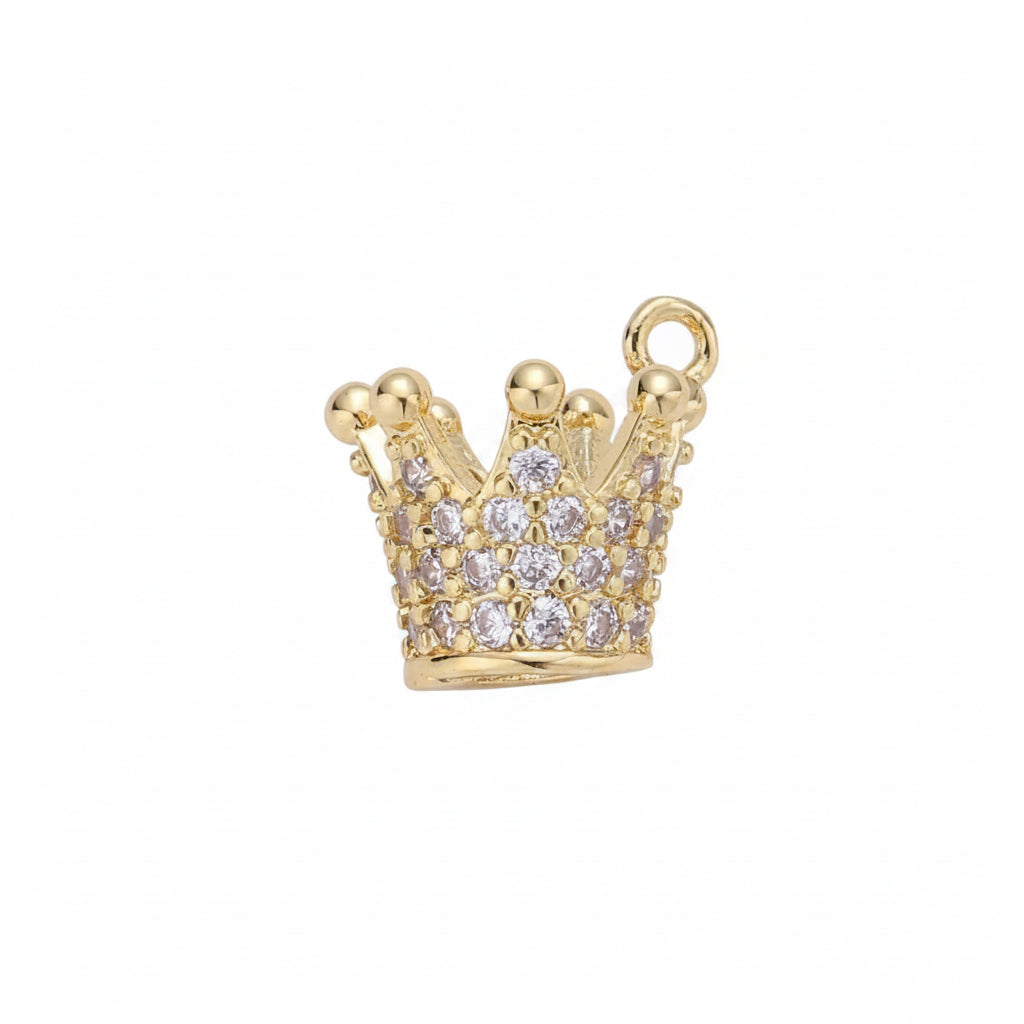 A gold crown-shaped jewelry charm or pendant embellished with clear rhinestones, shown on a plain light gray background.