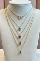 Gold chain necklace with colorful beads on a mannequin bust.