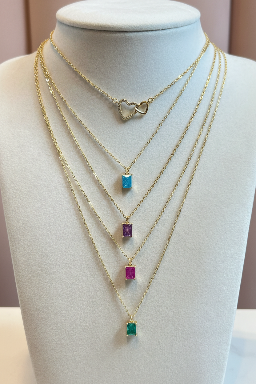 Gold chain necklace with colorful beads on a mannequin bust.