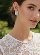 Woman wearing a white lace top with a blurred outdoor background